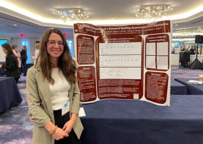 Research student posing in front of her poster.