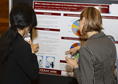 Two people discussing a research poster at the 2025 Early Childhood Summit.