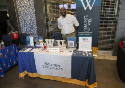 Man posing for a picture at his booth at the Texas Play & Development Conference.