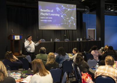 Man presenting a powerpoint in front of an audience at the Texas Play & Development Conference.