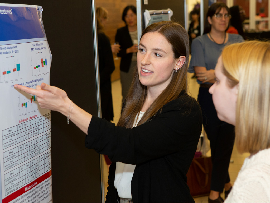 summit Woman pointing to a research poster at the 2025 Texas Early Childhood Summit